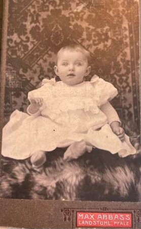 Foto Baby im Taufkleid vor Wandteppich