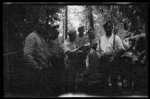 Offiziere mit Feldmützen im Wald bei eine Rasur, 1 Offizier mit Kopfverband