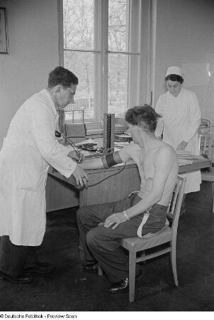 Arzt und Krankenschwester bei der Untersuchung eines Patienten