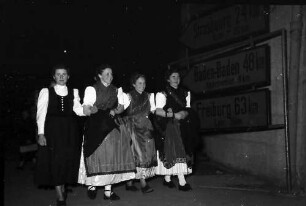 Offenburg: im Haus der Familie Schuller, Trachtengruppe vor Wegweiser