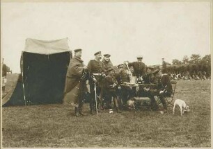 Biwak bei Jüterbog, teils stehend, teils sitzend um Tisch bei Essenszuteilung, acht Offiziere in Uniform und Mütze, Brustbilder vorwiegend in Halbprofil