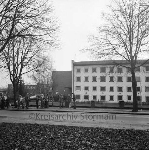 Alfred-Rust-Realschule: Wulfsdorfer Weg: Straßenfront: Schüler an der Bushaltestelle