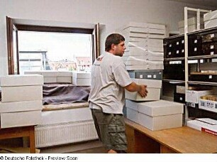 Umzug aus den dezentralen Standorten (Deutsche Fotothek und Stenografische Sammlung) in die Sächsische Landesbibliothek - Staats- und Universitätsbibliothek Dresden, Zentralbibliothek. Transportarbeiter im Positivmagazin (2. Obergeschoss) beim Beladen des Schrägaufzuges mit Magazinboxen : Dresden-Neustadt, Bautzner Straße 19. Umzug aus den dezentralen Standorten (Deutsche Fotothek und Stenografische Sammlung) in die Sächsische Landesbibliothek - Staats- und Universitätsbibliothek Dresden, Zentralbibliothek. Transportarbeiter im Positivmagazin (2. Obergeschoss) beim Beladen des Schrägaufzuges mit Magazinboxen