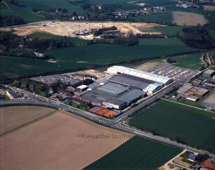 British American Tobacco (BAT): Luftbild des Gewerbegebietes am Beimoorweg: im Vordergrund Beimoorweg, im Hintergrund Baustelle für den neuen Stadtteil Gartenholz