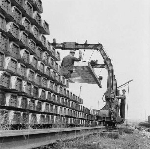 Rethwisch. Betonwerk der Deutschen Reichsbahn. Lagerplatz mit Betonschwellenstapel und schienenverfahrbarem Portalkran