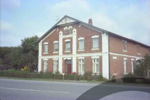 Hoisbüttel: Lübecker Straße 19: giebelständiges Bauernhaus aus Backstein: Straßenfront Wohntrakt mit Lisenen, Gesims, Eingangstür und hölzerner Giebelzier: Traufseite