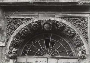 Görlitz, Nikolaistraße 10. Wohnhaus (bezeichnet 1583, nach 1717 Obergeschoss). Sitznischenportal. Detail: Oberlicht und Schlußstein mit Enge, ein Schild haltend