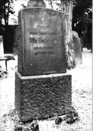 Grabstein 514 (Index: 99630015) Material: Granit mit geschliffener Platte Zustand: leicht verwittert Maße HxBxT: 125x56x32 cm Beschreibung: Stele auf Sockel, Segmentbogenabschluß Symbolik: sechszackiger Stern: Grabstein 514