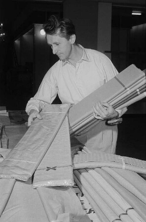 Ein Mitarbeiter der tschechoslowakischen Kollektivausstellung beim Auspacken von Stoffen auf der Leipziger Herbstmesse 1955