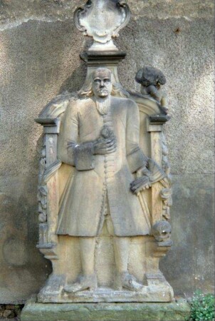 Grabstein an Kirchenwand; Mann im Gehrock
