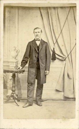 Porträtfoto eines stehenden jungen Mannes