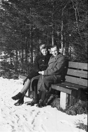 Paar auf einer Bank in winterlicher Landschaft