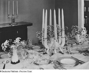 Innenraum mit gedecktem Tisch (1925/1930; Deutsche Werkstätten Hellerau). Hochzeits-Festtafel in einem Speisezimmer, Sechsarmiger Kerzenständer