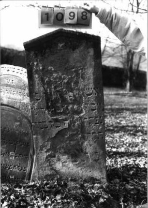 Grabstein 1098 (Index: 99753290) Material: Sandstein Zustand: abgeblättert/Textverlust groß Maße HxBxT: 110x50x10 cm Beschreibung: Stele, giebelartiger Abschluß mit Verdachung: Grabstein 1098
