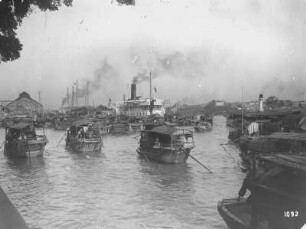 Kanton (Guangzhou), China. Pearl River mit zwei Passagierdampfern und zahlreichen Dschunken gegen Hafen