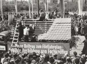 Dresden. Maidemonstration 1951 : Demonstrationszug von der Güntzstraße zum Straßburger Platz (Fucikplatz) in Dresden mit Schauwagen und Parole "Unser Beitrag zum Fünfjahrplan: Erhöhte Ausbildung von Fachkräften"