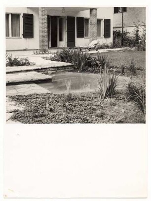 Garten [noch nicht indentifiziert]: Wasserbecken und Terrasse am Haus, Sonnenliege, weißes Haus, gemauerte Stütze