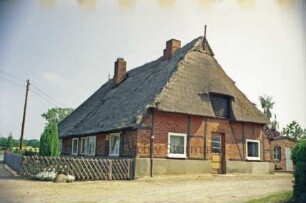 Poggensee 12: Kate mit Reetdach: Giebelseite mit Gaube zum Heuboden und Eingangstür: Traufseite