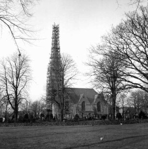 Friedenskirche: Turm mit Gerüst: Blick von Süden: vorn Dorfanger: dahinter Kirchhof und Bäume
