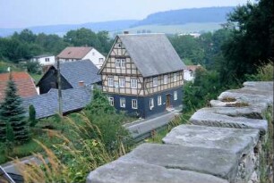 Blick über Friedhofsmauer auf das Dorf
