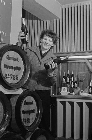 Eine Dame präsentiert an einem Messestand Bier aus der Grenzquell-Brauerei, Wernesgrün