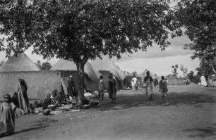 Straße durch Ngaoundéré : Am Rande der Straße durch Ngaoundéré sitzen Frauen und bereiten Essen zu.