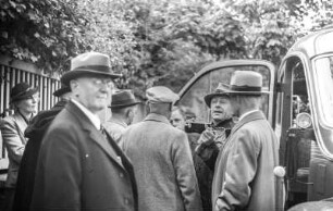 Reise-Gruppe : Eine Gruppe Reisender vor einem Omnibus.