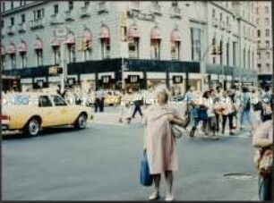 Ältere Dame mit Einkauftasche auf einer Straßenkreuzung in Amerika (Altersgruppe 18-21)