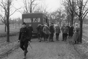 Männergruppe in Uniformen : Männer in Uniformen vor einem Bus