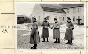 Angehörige der Ordnungspolizei auf einem Innenhof vor einem Gebäude