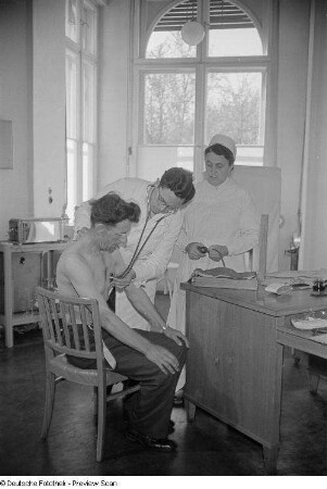 Arzt und Krankenschwester bei der Untersuchung eines Patienten