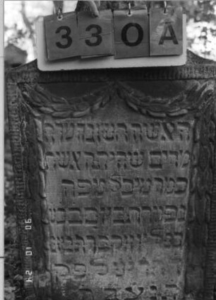 Grabstein 330 (Index: 100115817) Material: Sandstein Zustand: verwittert Maße HxBxT: 95x55x15 cm Beschreibung: Stele mit konkav eingezogenem Segmentbogenabschluß, eingetieftes Schriftfeld Symbolik: das Schriftfeld einrahmende Ranken, Blüte: Grabstein 330A