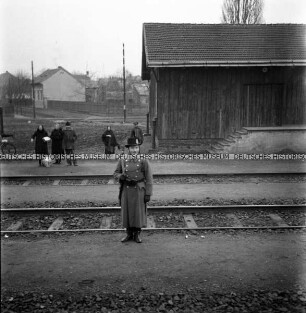 Ein ungarischer Soldat an Bahngleisen, aus dem Zug fotografiert