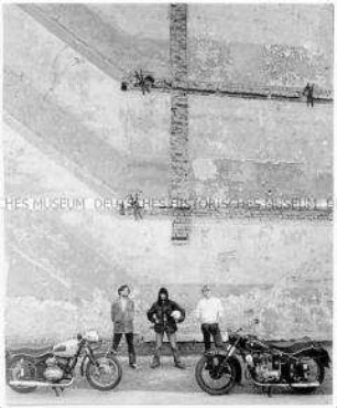 Zwei Männer, eine Frau und zwei Motorräder (Altersgruppe 18-21)