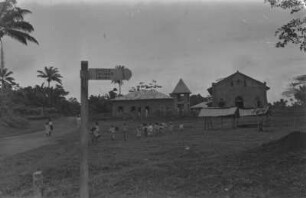 Straßenszene : Straßenszene in einem Dorf mit Kirche, Schule und spielenden Kindern.