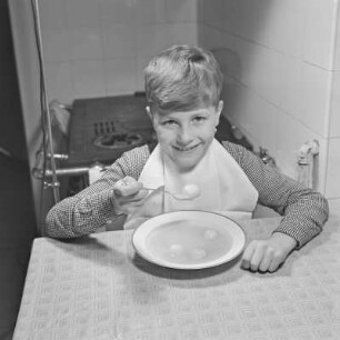 Junge isst Suppe mit Klößchen