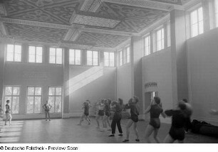 Sportlerinnen während einer Übung mit einem Medizinball in einer Sporthalle der Deutschen Hochschule für Körperkultur in Leipzig