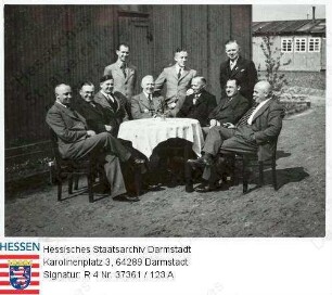 Rodgau, Strafgefangenenlager II Rollwald (1938-1945) / Verwaltungsbeamte an Tisch vor Baracke sitzend, Gruppenaufnahme