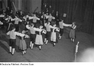 Blick auf die Bühne mit einer Tanzgruppe und einem Orchester