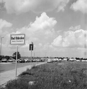 Rögen: Gewerbegebiet West: Ortseingangsschild: Einbahnstraßenschild, Straßenschild: parkende Autos, Straßenlampen: im Hintergrund Hallen von Gewerbebetrieben