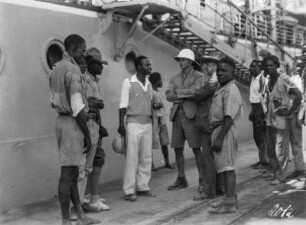 Männer vor einem Schiff : Eine Gruppe Männer vor einem Schiff