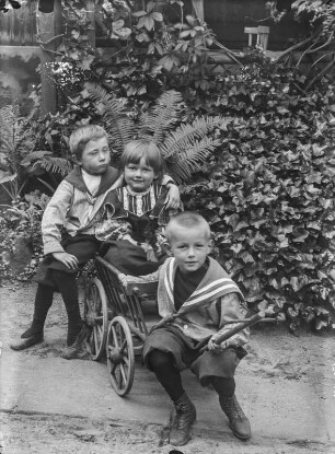 Kinder mit Leiterwagen im Garten