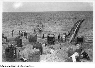 Blick über den Strand mit Urlaubern, Strandkörben und Wellenbrecher in der Ostsee
