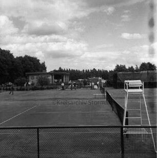 Tremsbüttel-Dorf: Sportanlagen: Tennisanlage: vorn Tennisfelder mit Netzen und Zäunen: vorn rechts Hochsitz des Schiedsrichters: hinten links Sportlerheim: rechts Flohmarktstände mit Sonnenschirmen: dazwischen Besucher