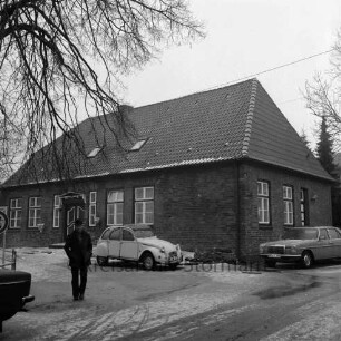 Evangelische Kirchengemeinde: Predigerwitwenhaus: am Neuhöfer Teich, Ecke Lokfelder Damm: Außenaufnahme: davor parkende Autos, Mann: vorne links Äste von Baum: im Winter