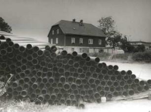 Zinnwald-Georgenfeld. Röhrenlager gegen Wohnhaus, Teplitzer Straße und Grenzübergangsstelle