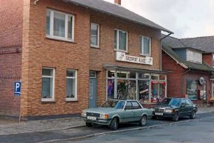 Jersbeker Straße 11: traufständiges Backsteinhaus: Straßenfront mit moderner Ziegelverkleidung, Eingangstür, Geschäft "Radsport Runge", Schaufenster