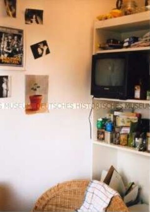 Blick auf ein Regal mit Fernseher und Korbstuhl im Vordergrund (Prämiertes Foto Sonderthema: Familienbilder)