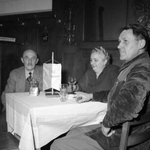 Club der Einsamen. Zwei ältere Männer und eine ältere Frau, am Stammtisch sitzend