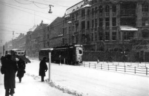 Berlin. Straßenzug. Blick gegen Wohn- und Geschäftshäuser. Ansicht mit Straßenbahnzug